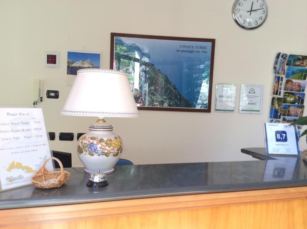 a lamp sitting on top of a counter with a clock at Hotel Il Saraceno in Volastra