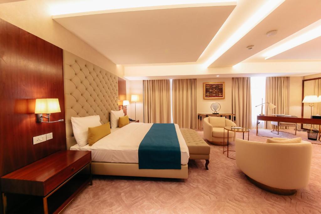 ニアメにあるBravia Hotel Niameyのベッドとデスクが備わるホテルルームです。