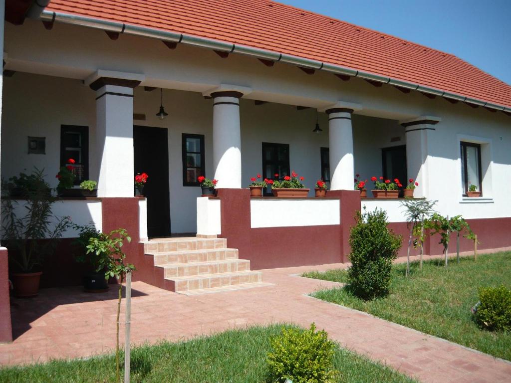 a house with columns and flowers in a yard at Álmosdi Tópart Vendégház in Álmosd