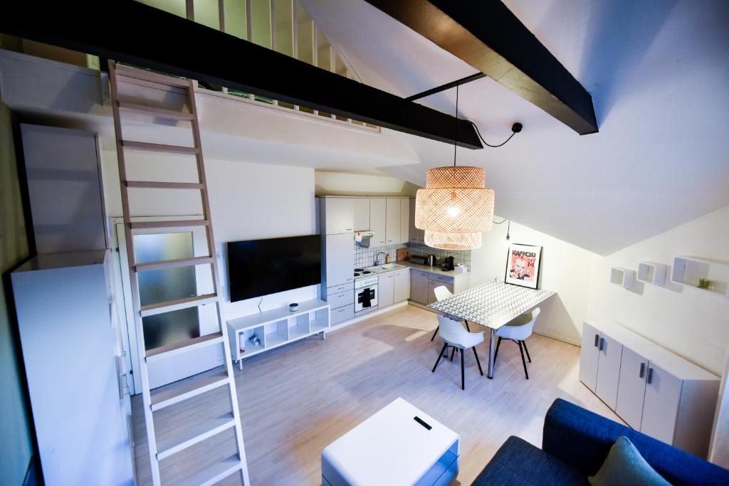 Apartamento tipo loft con escalera, mesa y sillas en SKYHIGH STUDIO STP, en Sankt Pölten