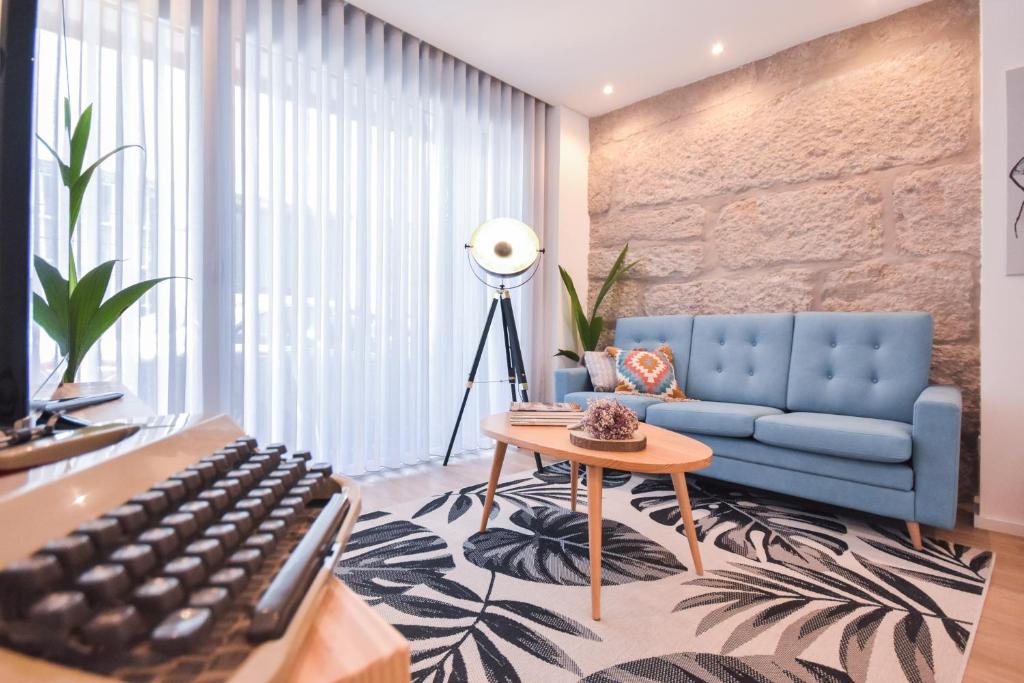 a living room with a blue couch and a keyboard at Oporto lovely house deluxe in Porto