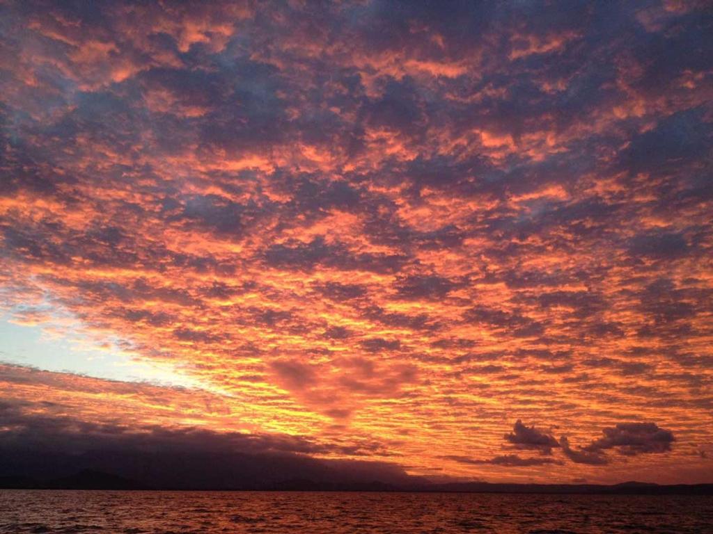 un ciel nuageux sur l'océan au coucher du soleil dans l'établissement Cosy Studio, à Port Douglas