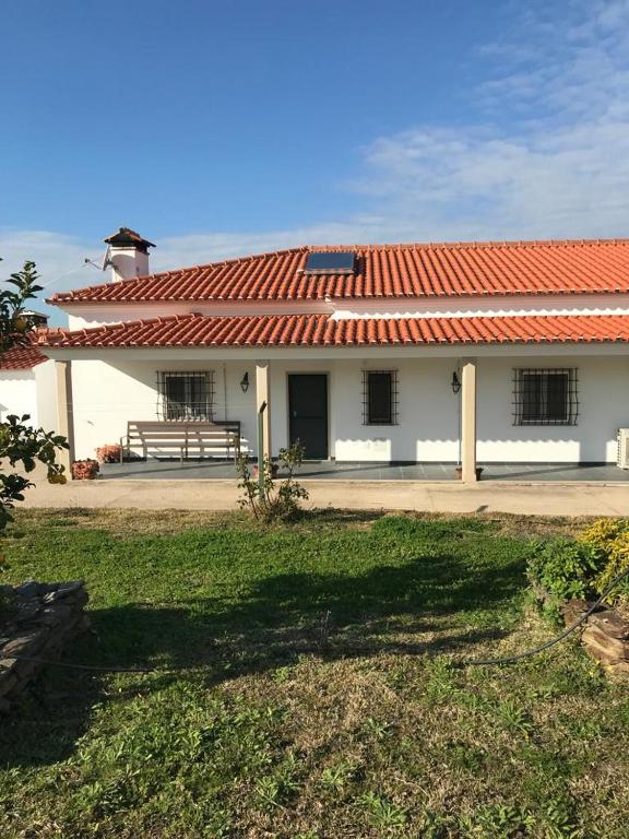 a building with a red roof with a bench in front at Moradia Gémea em Herdade Santa Marta in Zebreira