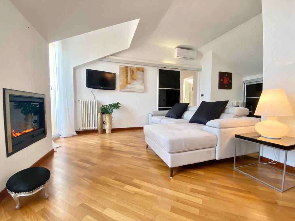 - un salon avec un canapé blanc et une cheminée dans l'établissement CasaViva - Central Seaview Penthouse in Camogli, à Camogli
