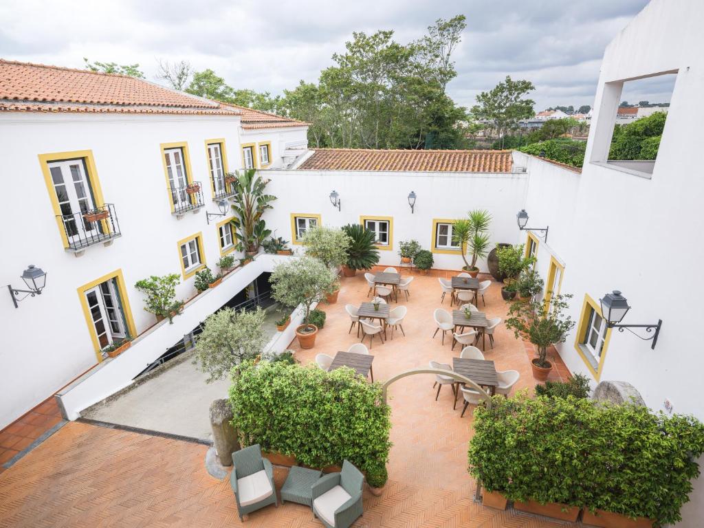 エヴォラにあるADC - Albergaria Do Calvário - by Unlock Hotelsのテーブルと椅子が備わる中庭の景色を望めます。
