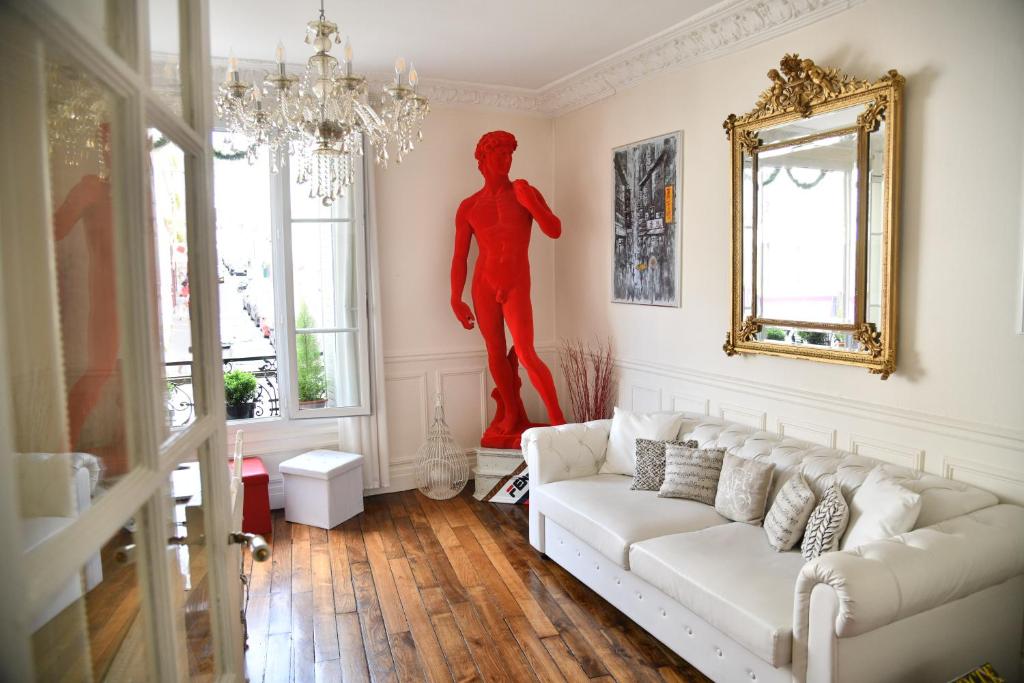 uma sala de estar com um sofá branco e uma estátua vermelha em Van Gogh's Apartment - Montmartre em Paris