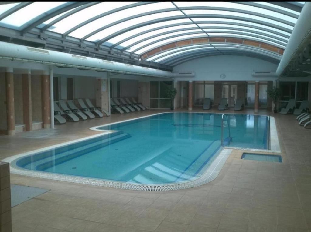 une grande piscine avec un plafond en verre dans l'établissement Sweet Apartman Zalakaros, à Zalakaros