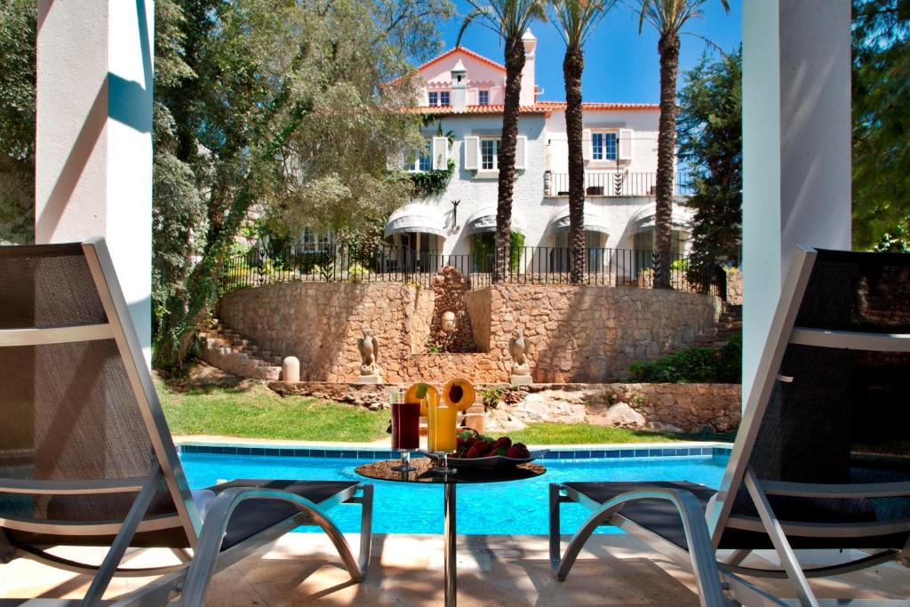 a patio with a table and chairs next to a pool at Casa Vela Boutique House in Cascais