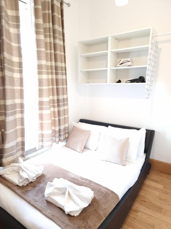 uma cama com duas toalhas num quarto em F204-Compact 2nd Flr Studio Fits 2-Near Hyde Park em Londres