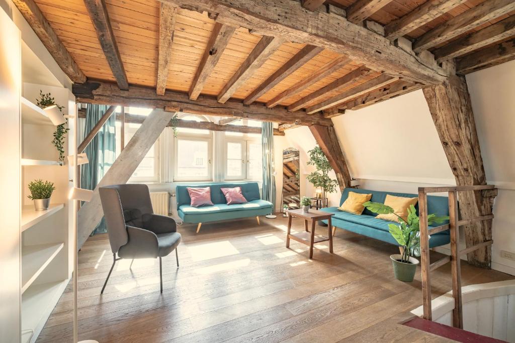 - un salon avec des plafonds en bois et des canapés bleus dans l'établissement The Hendrik House in Old Town Antwerp, à Anvers