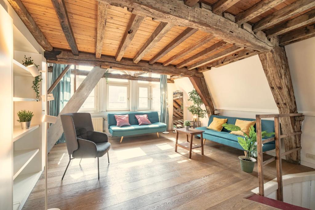 a living room with wooden ceilings and blue couches at The Hendrik House in Old Town Antwerp in Antwerp
