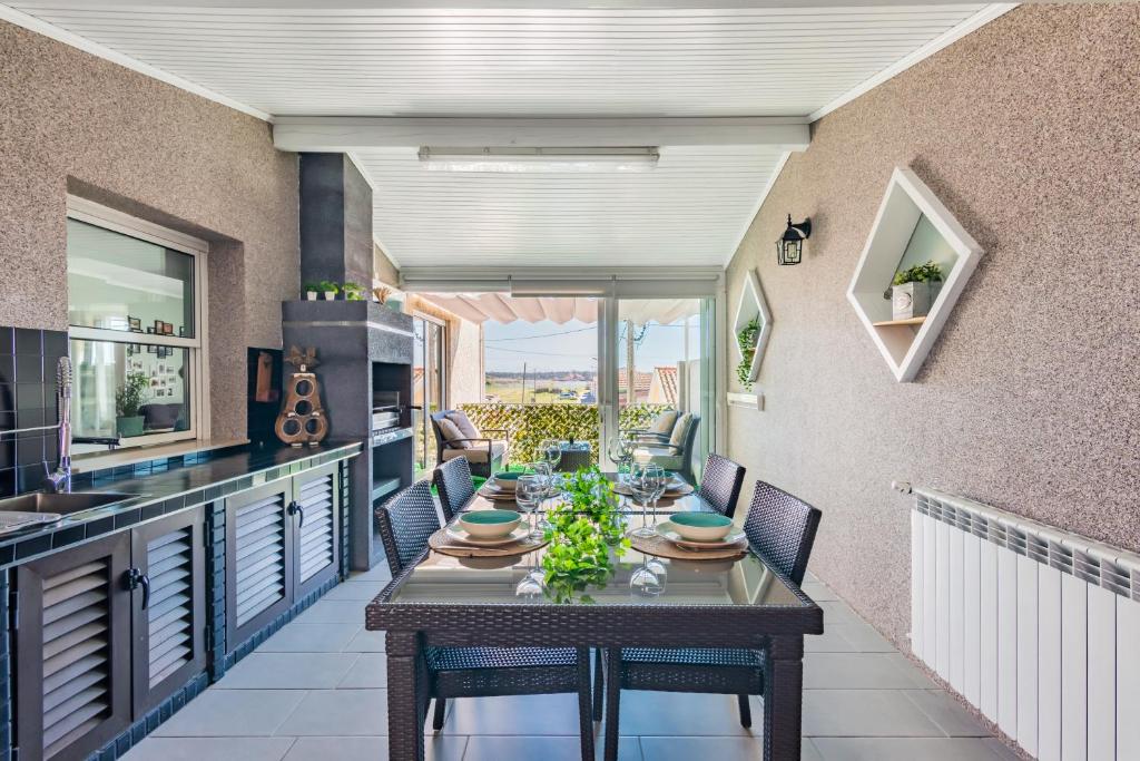 a kitchen and dining room with a table on a balcony at Bela Vista - Beach Apartment in Praia de Mira