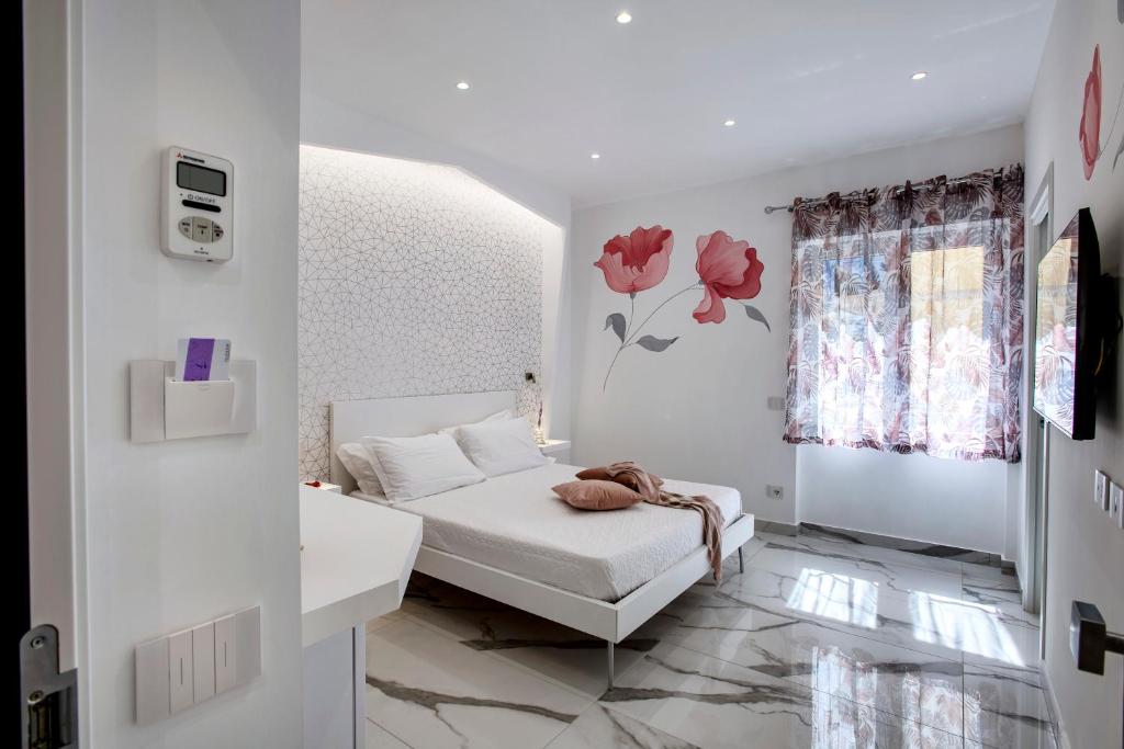 una camera bianca con un letto e una finestra di Maison Marienne - Deluxe B&B a Sorrento
