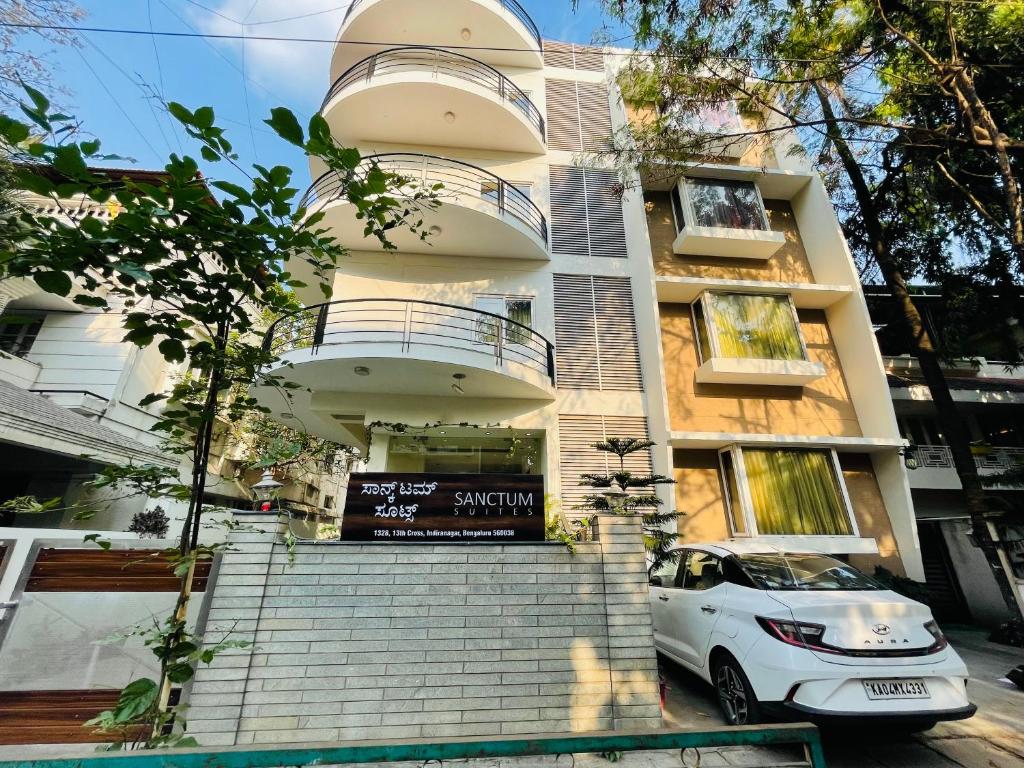 バンガロールにあるSanctum Suites Indiranagar Bangaloreの建物前に駐車した白車