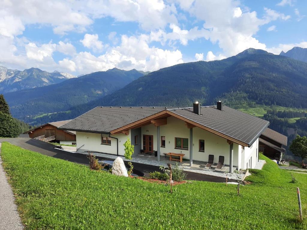 a house on a hill with mountains in the background at Panoramablick Tscheltsch in Liesing