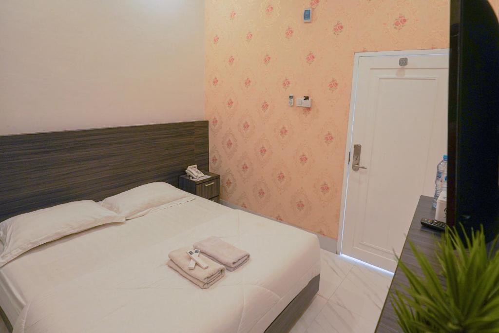 sypialnia z białym łóżkiem z torebką w obiekcie Wisma D’King RedPartner w mieście Pangkajene