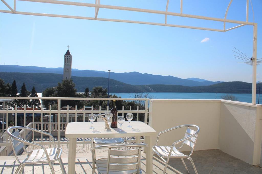 a white table and chairs on a balcony with a view at Apartment Dora in Neum