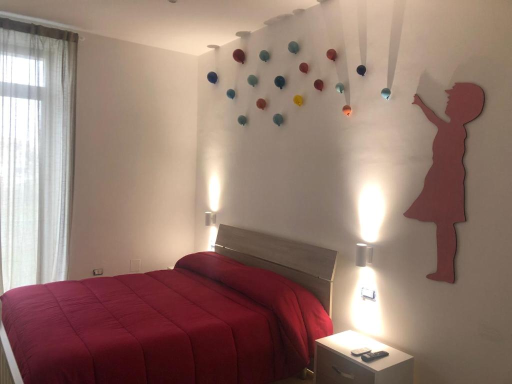 um quarto com uma cama vermelha e uma parede com uma rapariga em Casa Dalila em Vietri