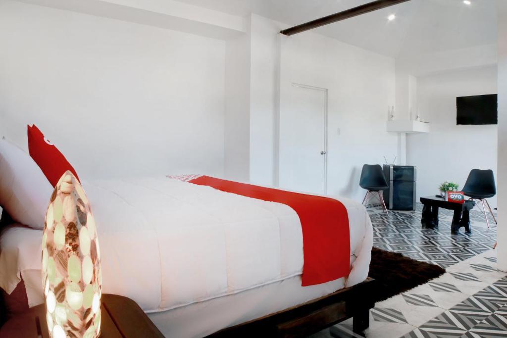 - une chambre avec un lit blanc et un salon dans l'établissement OYO Hotel Maria Otilia Falla, Papantla, à Papantla