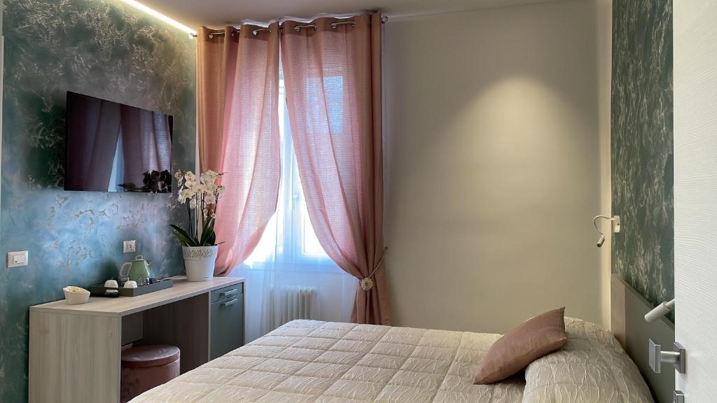 a bedroom with a bed and a desk and a window at La casa di Celeste B&B in Comacchio