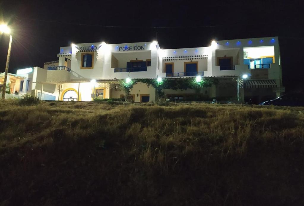 Un grand bâtiment blanc avec des lumières la nuit dans l'établissement Studio Poseidon, à Lipsi