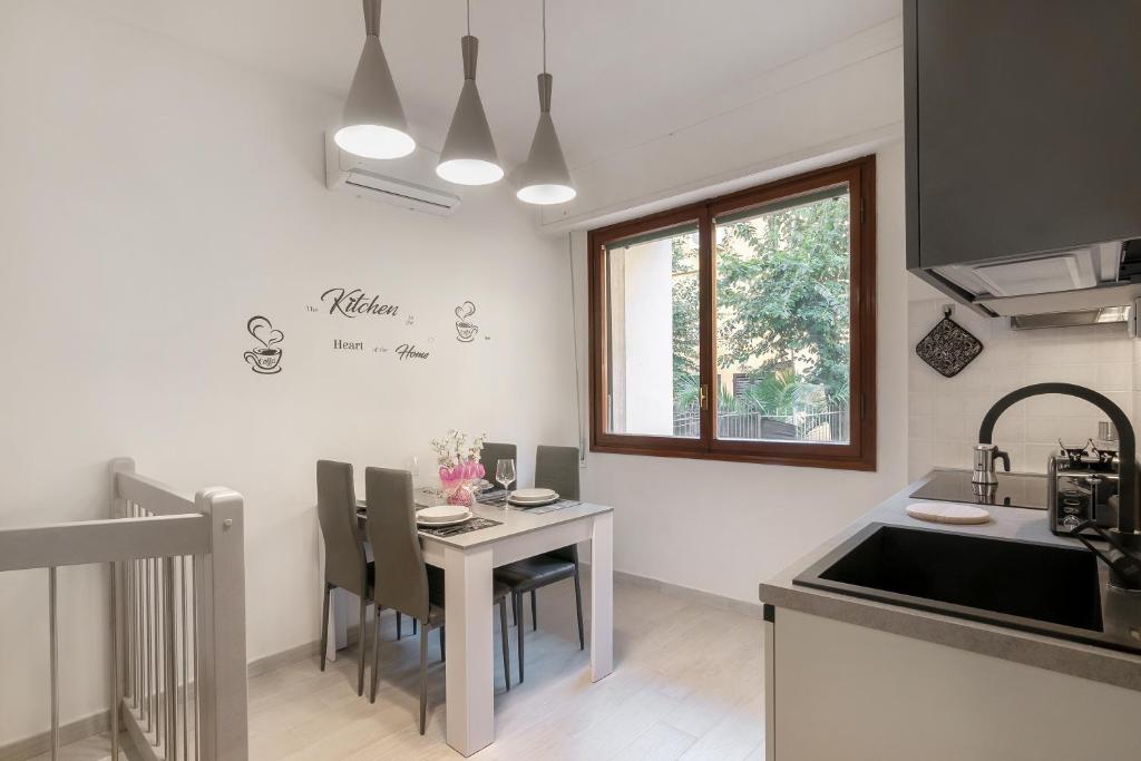 a kitchen with a table with chairs and a sink at Bellariva Home in Florence