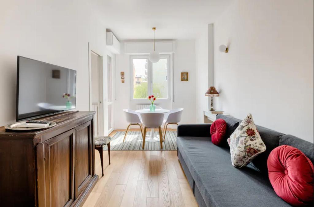 uma sala de estar com um sofá e uma televisão de ecrã plano em Ripa Apartments Milano - Pastorelli em Milão