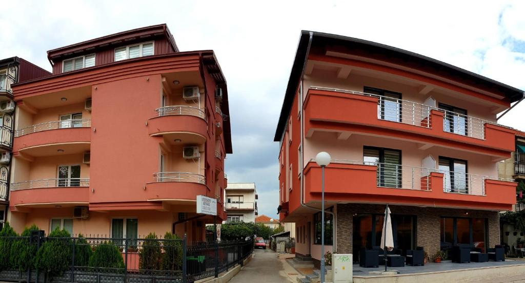 a red building next to another building at Villa & Apartments Antigona in Ohrid