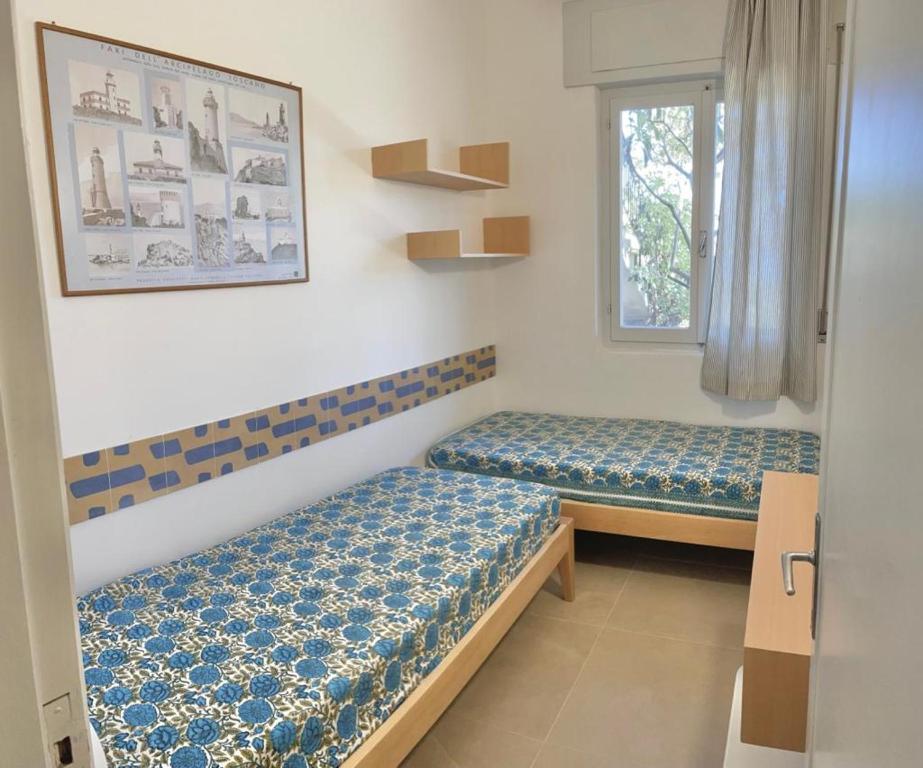 a room with two beds and a window at Residence Capobianco in Portoferraio