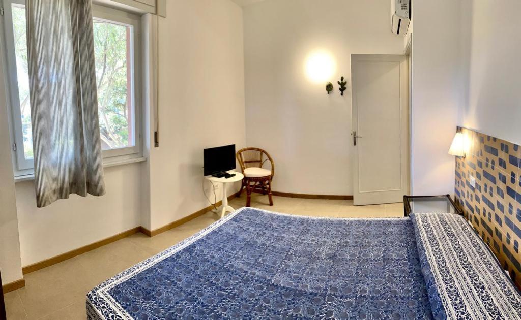 a bedroom with a large bed and a window at Residence Capobianco in Portoferraio