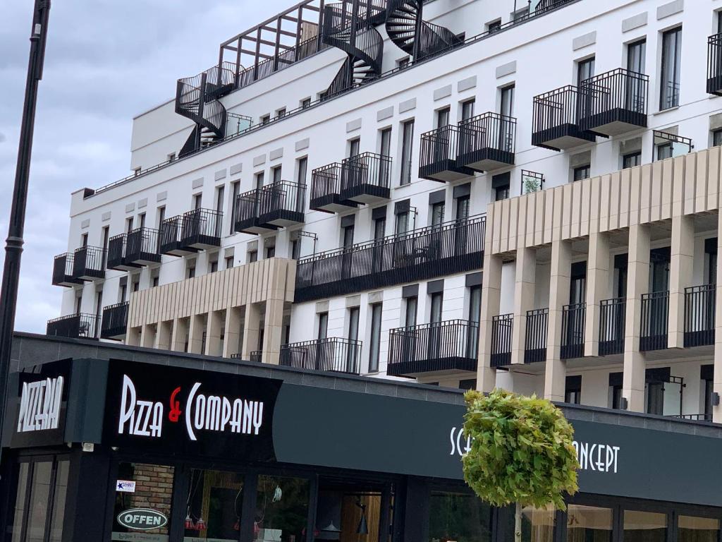 un edificio blanco con balcones en un lateral en Apartament LENA F407 Uzdrowiskowa PARK, en Świnoujście