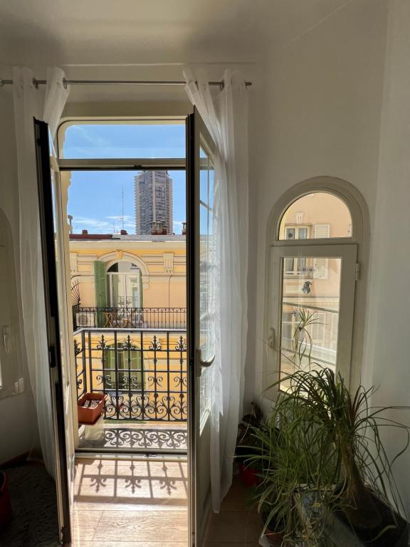 une porte donnant sur un balcon avec vue sur un bâtiment dans l'établissement Charming Sunny Apartment across Monte Carlo Casino, à Beausoleil