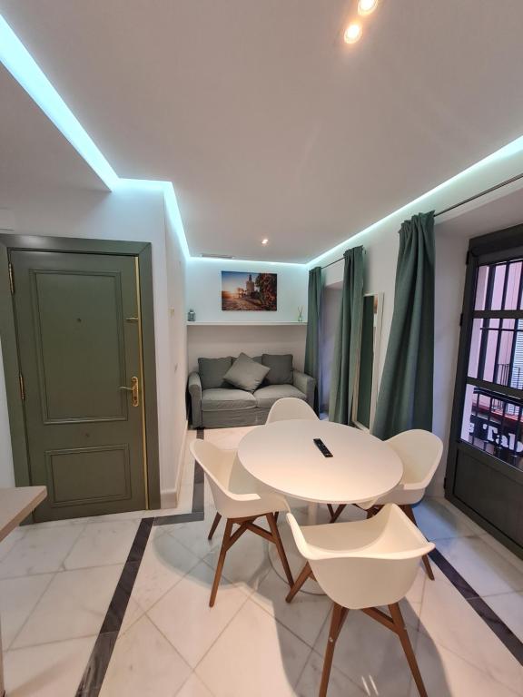 ein Wohnzimmer mit einem Tisch, Stühlen und einem Sofa in der Unterkunft DreamsApt Sierpes in Sevilla