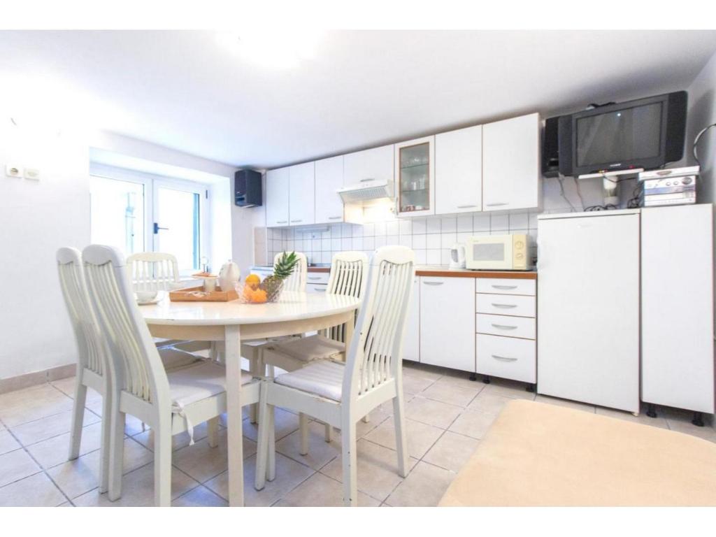 a kitchen with a table and chairs in a kitchen at Apartment Primosten Center in Primošten