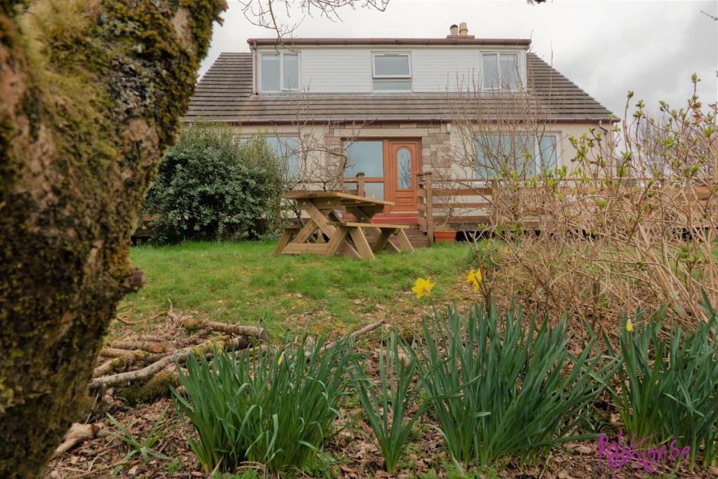 a house with a picnic table in the yard at Remuera, North Tolsta in North Tolsta
