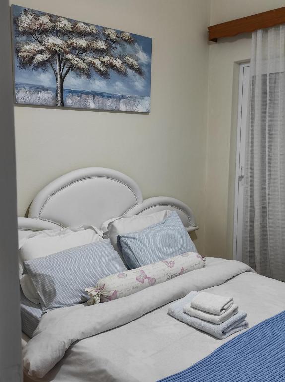 Una cama blanca con toallas encima. en KROKOS HOUSE en Aliveri