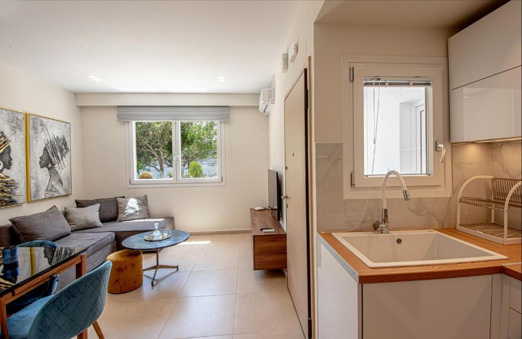 cocina y sala de estar con sofá y lavamanos en Luxury Apartment Marine View, en Agios Nikolaos