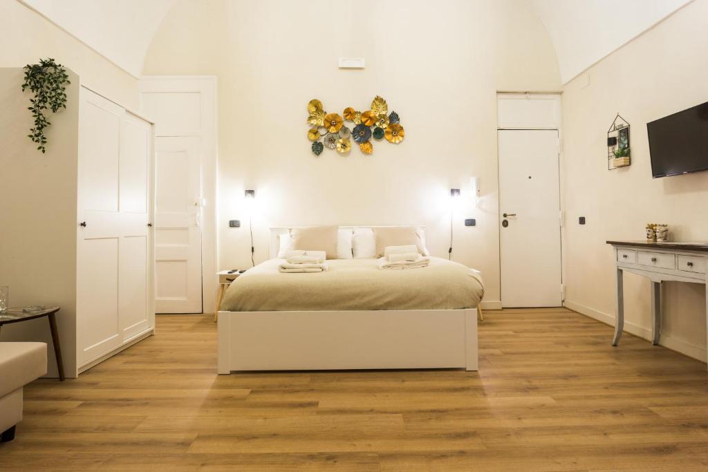 a white bedroom with a bed and a table at Residenza Sforza Apartment 1 in Naples