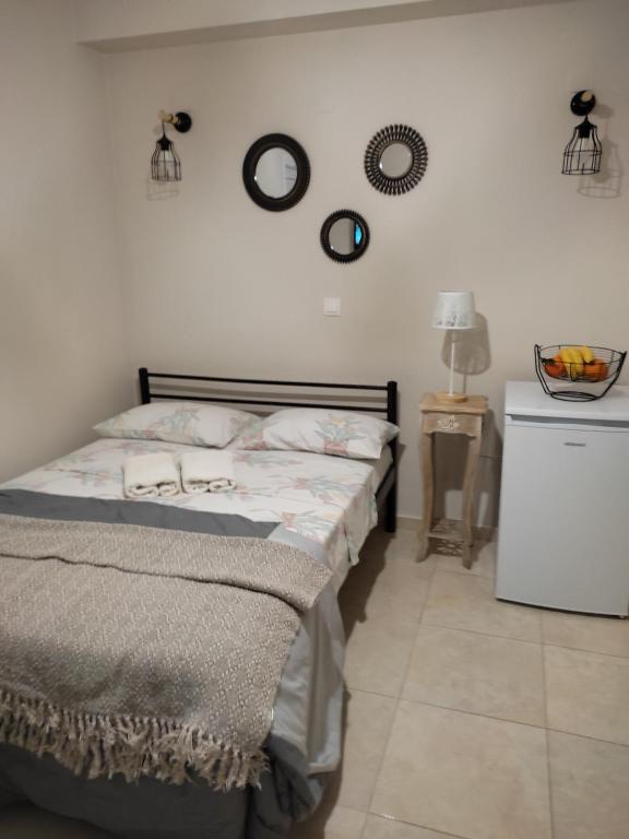 a bedroom with a bed and two mirrors on the wall at DORA'S APARTMENTS STUDIO 1 in Corfu Town
