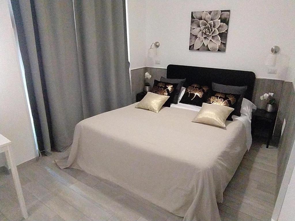 - une chambre avec un grand lit blanc et quatre oreillers dans l'établissement Apartment Marifra Garden, à Taormine
