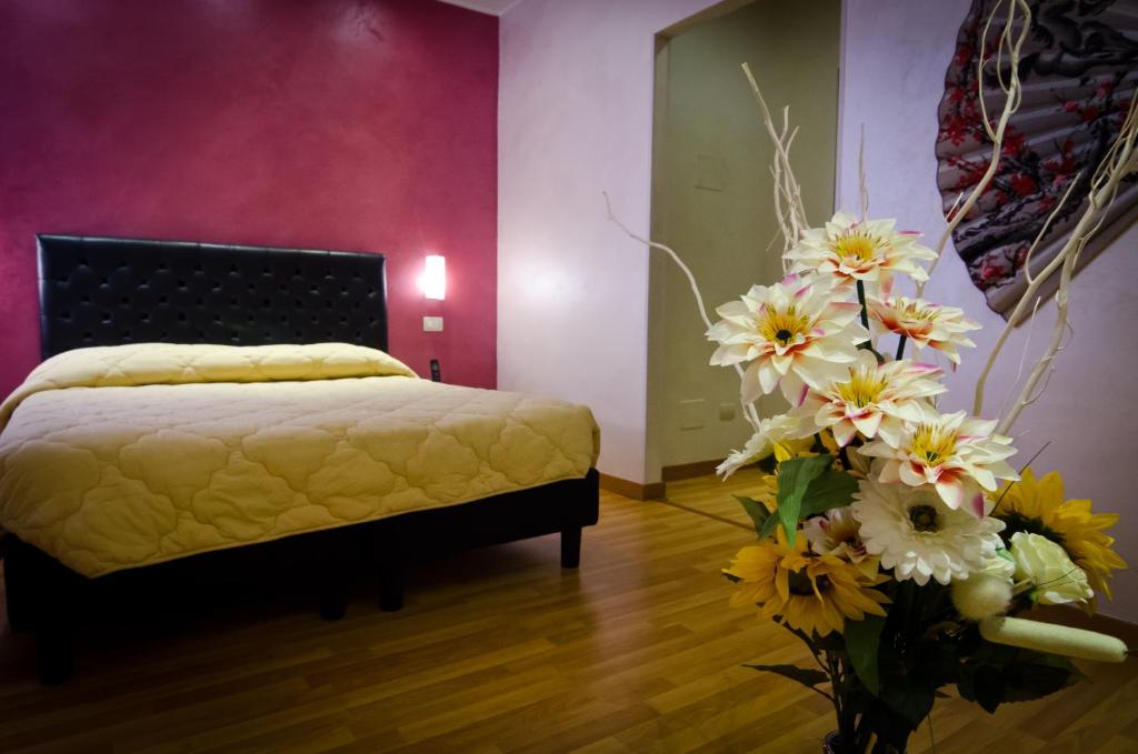 a bedroom with a bed and a vase of flowers at Via Palazzo Sanremo in Sanremo