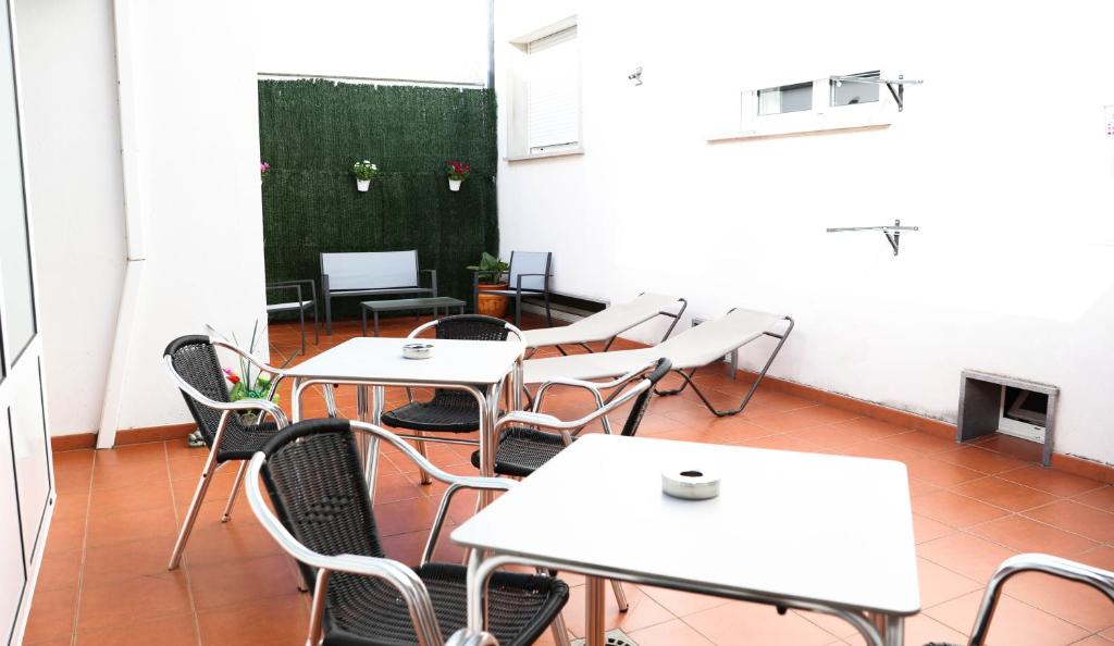 una habitación con mesas, sillas y una pizarra en PENSIÓN EL CAMINANTE, en Portomarín