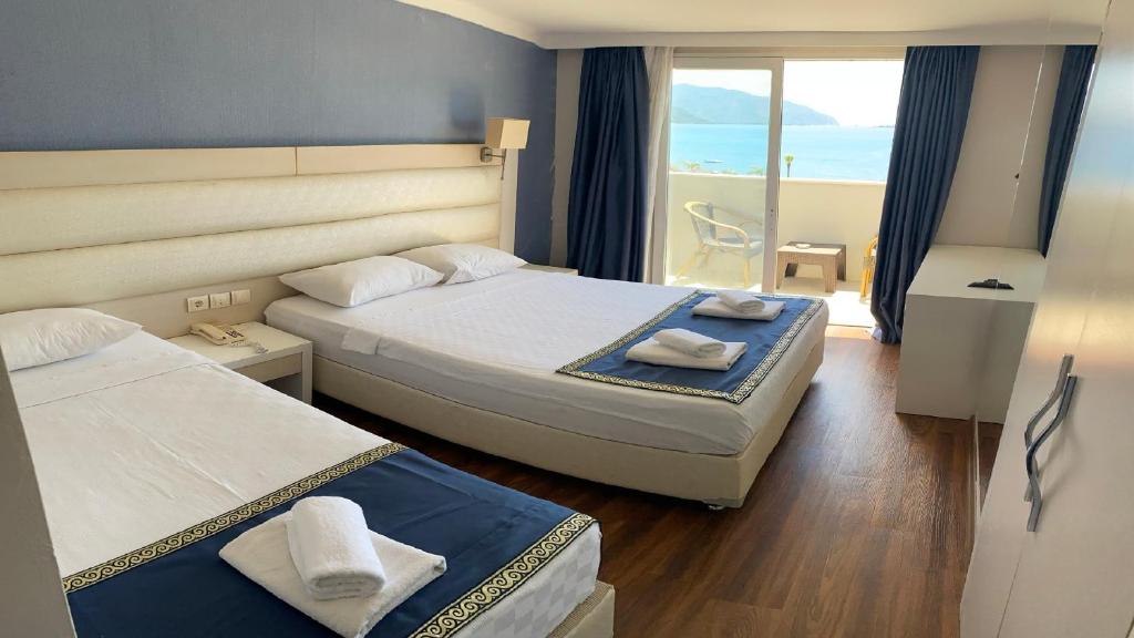 een hotelkamer met 2 bedden en een balkon bij GOLDKAYA HOTEL in Marmaris