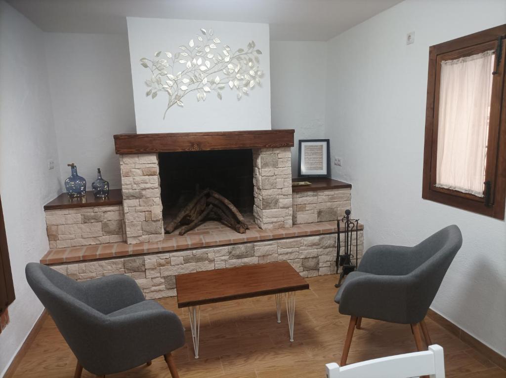 a living room with two chairs and a fireplace at Casa La Piedra in Segura de la Sierra