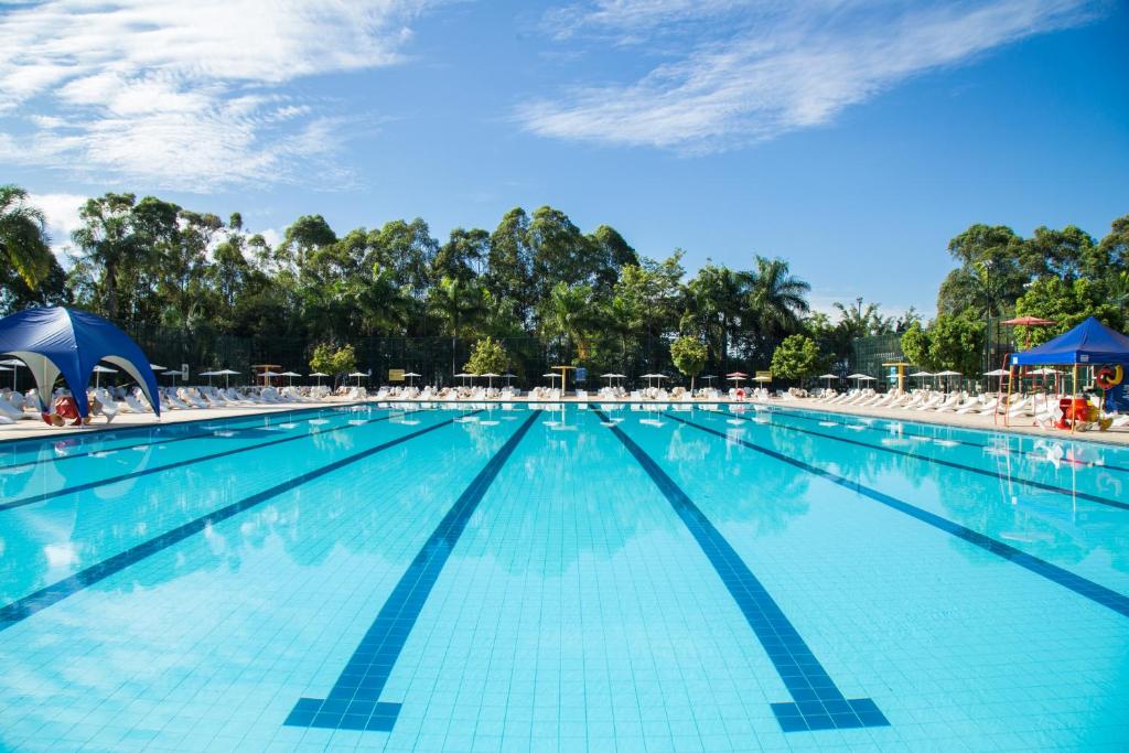 a swimming pool with chairs and umbrellas at SESC CONTAGEM in Contagem