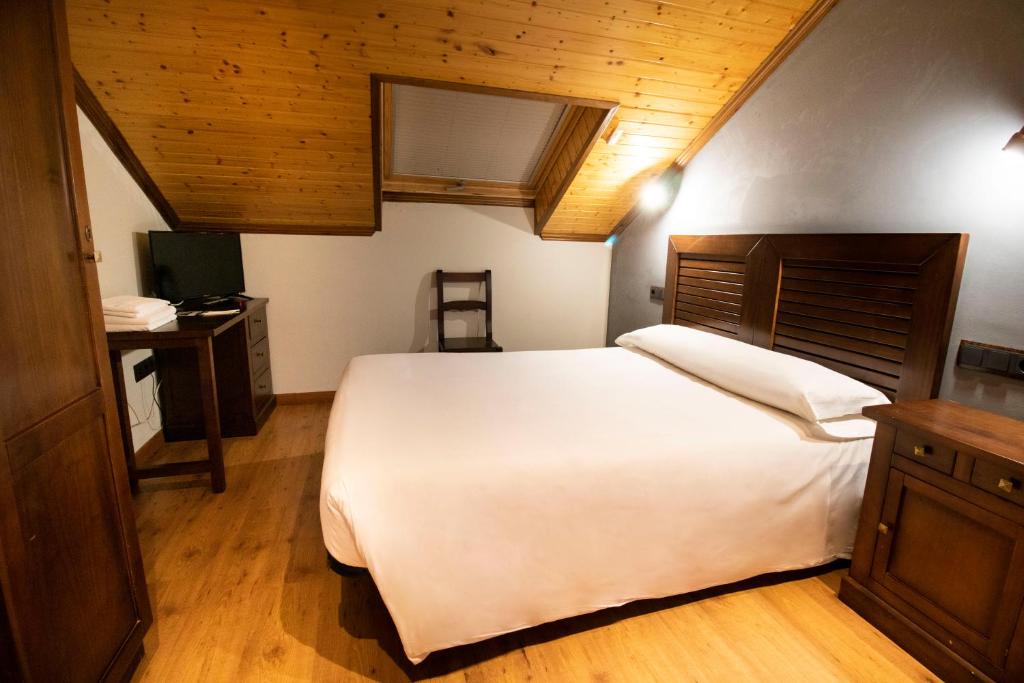 a bedroom with a large white bed and a desk at Alda Casco Antiguo in León