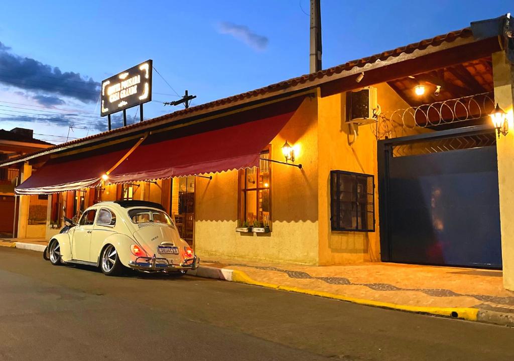 an old white car parked outside of a building at Hotel Casa Grande in Pôrto Ferreira