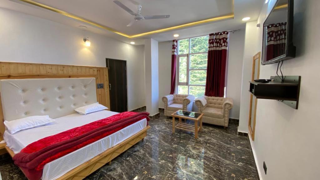 1 dormitorio con 1 cama, TV y sofá en Edenroc.khajjiar, en Khajjiar 