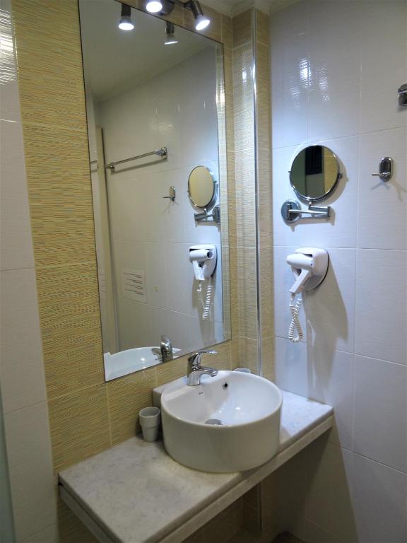 a bathroom with a sink and a mirror at Horizon Beach Hotel in Plakias