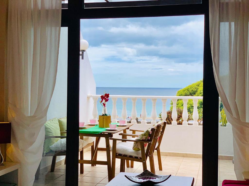 ein Esszimmer mit Tisch und Blick auf das Meer in der Unterkunft Casahost - Casa Elu Lanzarote in Puerto del Carmen